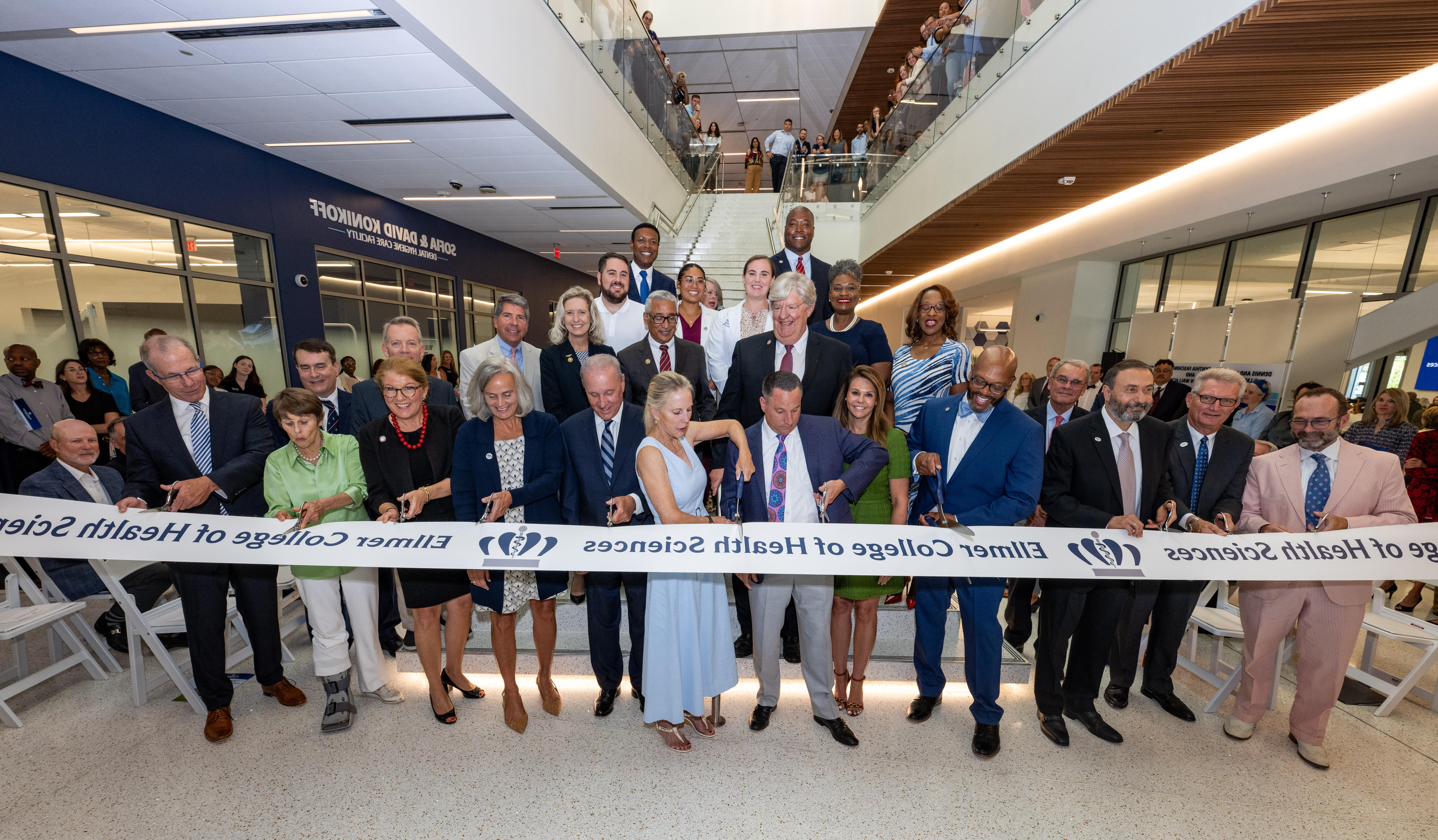 group of people cutting a grand opening ribbon